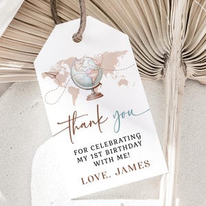 May include: White gift tag with a world map and globe illustration. The tag reads "thank you" and "For celebrating my 1st birthday with me! Love, James."