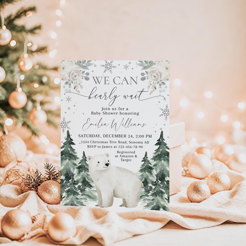 A white invitation card with a winter theme, featuring a polar bear and snowflakes, placed on a table with Christmas ornaments and lights in the background.