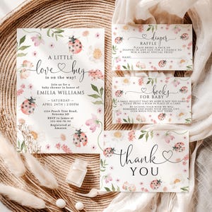 May include: A collection of baby shower stationery with a floral and ladybug theme. The invitation reads "A Little Love Bug is on the way!" and includes details for the event. Additional cards include a diaper raffle and a request for books.
