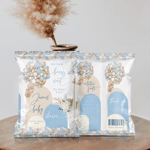 May include: Blue and gold baby shower favor bags with a teddy bear balloon design. The bags say "We can bearly wait to meet you!" and "James baby shower April 24th, 202x".
