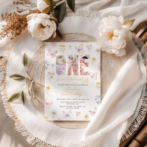 Peut inclure: Une invitation d'anniversaire aux couleurs pastel avec le mot "ONE" et des photos d'un bébé. L'invitation est décorée de papillons et de fleurs. Le texte comprend le nom du bébé, la date, l'heure, le lieu et les coordonnées RSVP.