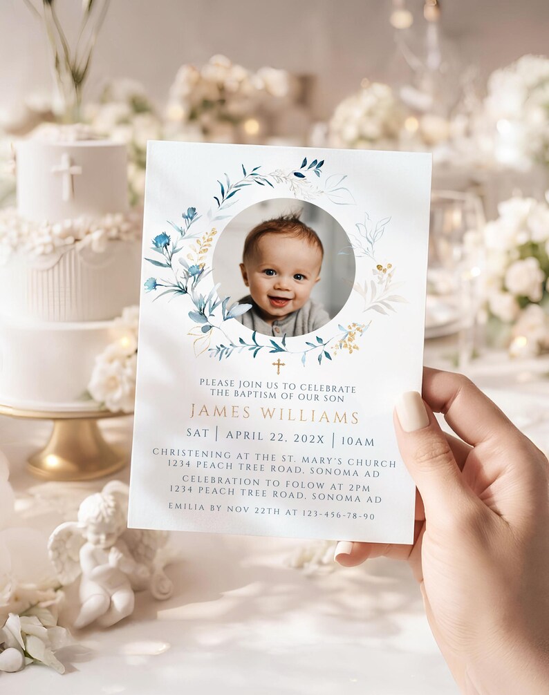 May include: A baptism invitation card featuring a baby's photo within a floral wreath. The card includes the text "James Williams" and event details. The design incorporates blue and gold accents, with a cross symbol.