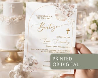 May include: A rectangular baptism invitation card featuring a gold arched frame, floral illustrations in soft beige and pink tones, and a small cross icon. The text reads ACOMPAÑANOS A SER PARTE DEL Bautizo DE NUESTRA HIJA Lucia Fernandez.