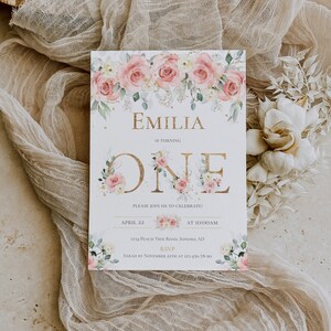 May include: A rectangular birthday invitation card featuring a watercolor floral border of pink roses and green leaves. The text reads EMILIA IS TURNING ONE, PLEASE JOIN US TO CELEBRATE, APRIL 22 AT 10:00AM, 1234 PEACH TREE ROAD, SONOMA AD, RSVP SARAH BY NOVEMBER 22TH AT 123-456-78-90.