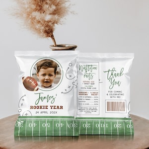 May include: Two white bags with a green football field design. One bag has a photo of a baby boy with the text "James' Rookie Year 24 April 202X". The other bag has the text "Thank You For Coming & Celebrating With Me!" and a nutrition facts label with the text "Nutrition Facts Serving Size: 1 Sweet Baby Calories: 100% Pure Love Amount/% Daily Serving Value: Love & Happiness 100% Family & Friends 100% Laughter 100% Hugs & Kisses 100% Percentage Daily Values Are Based On Unconditional Love Happiness Fun And Laughter"