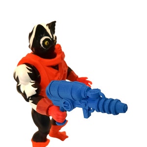 Könnte beinhalten: Eine blaue Spielzeugpistole aus Plastik mit einem Lauf und einem Griff. Die Pistole wird von einer schwarz-weißen Actionfigur mit rotem Oberkörper gehalten.