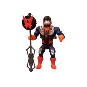 May include: Action figure of a character in a black, red, blue, and silver outfit. The figure is holding a staff with a red bat-shaped emblem. The character has a helmet and a mask. The figure is standing on a white background.