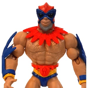 Puede incluir: Una figura de acción roja y azul con un tocado de plumas y un cinturón dorado. La figura tiene un cuerpo musculoso y una máscara sobre la cara.
