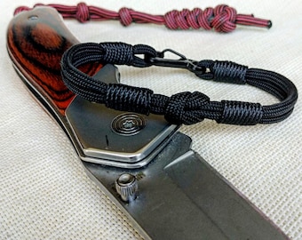 Thin military black bracelet made of paracord and carabine for men. Army style.