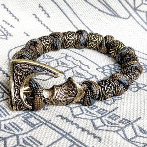 Viking bracelet made of paracord, Celtic knots and original beads made of brass with the image of ancient Scandinavian patterns. Mens style.