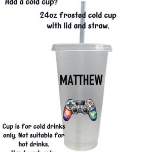 May include: A 24 ounce frosted cold cup with a lid and straw. The cup is personalized with the name "MATTHEW" and a colorful video game controller graphic. The text "Cup is for cold drinks only. Not suitable for hot drinks. Hand wash only." is printed on the bottom of the cup.