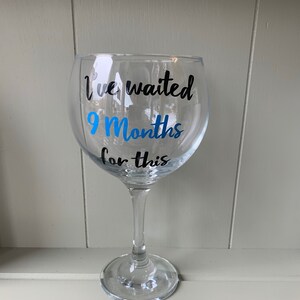 A clear glass gin glass with a black and blue vinyl sticker that reads "I've waited 9 Months for this".