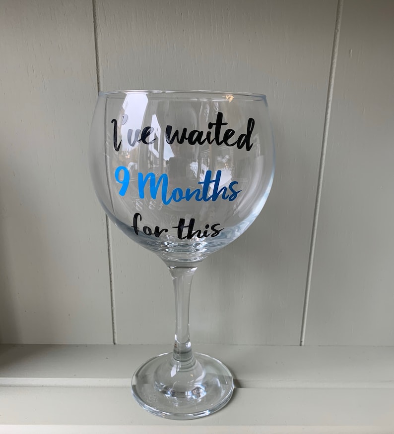 A clear glass gin glass with a black and blue vinyl sticker that reads "I've waited 9 Months for this".