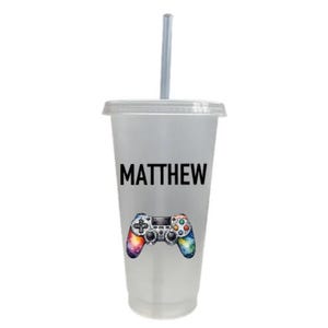 May include: A clear plastic tumbler with a straw, featuring a colorful video game controller graphic and the name "MATTHEW" printed on the side.