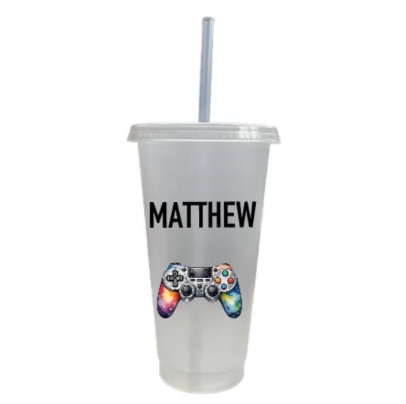 May include: A clear plastic tumbler with a straw, featuring a colorful video game controller graphic and the name "MATTHEW" printed on the side.