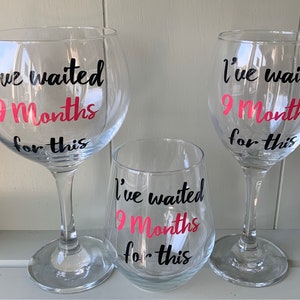 Three clear glass drinking glasses with black and pink lettering that reads "I've waited 9 Months for this".
