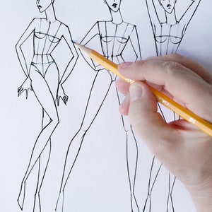 Pu&ograve; includere: Tre schizzi di design di moda di figure femminili con una matita in primo piano.