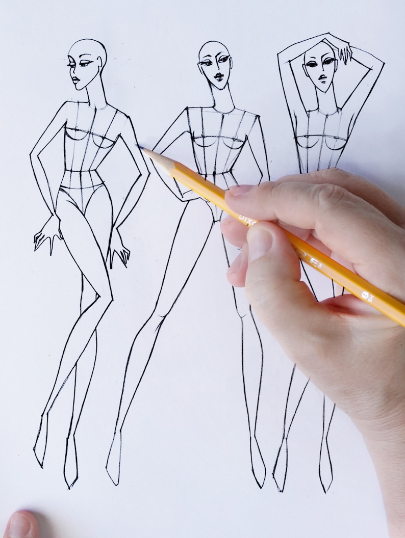 Pu&ograve; includere: Tre schizzi di design di moda di figure femminili con una matita in primo piano.