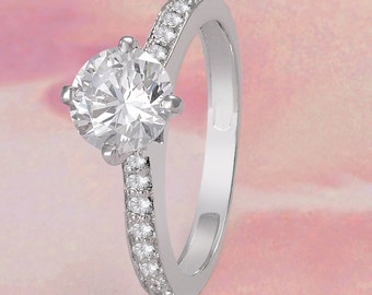 May include: A silver ring with a large, clear, round-cut center stone and a band of smaller, clear stones.