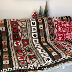May include: A handmade crochet blanket featuring a repeating pattern of squares and stripes in red, dark green, cream, and brown. A red throw pillow with white text including "Christmas Wishes" and "Winter" sits on the blanket.