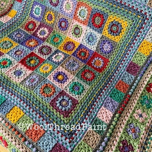 May include: A colourful crochet blanket featuring a variety of squares with different floral designs. The blanket is made with a mix of textures and colours, including red, green, blue, yellow, and purple. The blanket is bordered with a textured edging. The text "WoolThreadPaint" is visible in the lower right corner of the blanket.