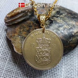 May include: A gold pendant necklace featuring a Danish 2 Kroner coin from 1953. The coin shows a royal crown and coat of arms. The necklace has a gold chain and a decorative bail. The text "DK Coin Items" is visible in the image.