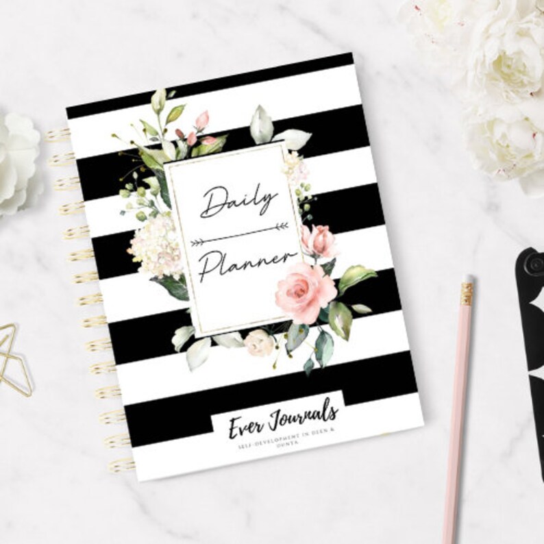 May include: Black and white striped daily planner with a floral design and gold accents. The planner has the text "Daily Planner" and "Ever Journals" on the cover.