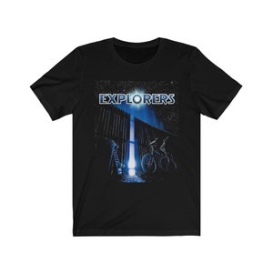 May include: Black t-shirt with a graphic of the movie "Explorers" featuring a bicycle and a gate with a bright light shining through it.
