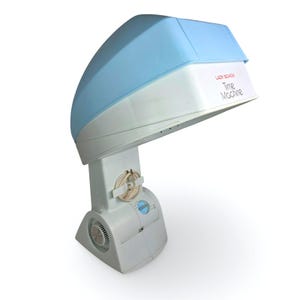 May include: A vintage Lady Schick Time Machine hair dryer. The hair dryer is white with a light blue top. The text "LADY SCHICK Time Machine" is printed on the front. The base has a fan and control dial.
