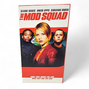 May include: A VHS tape for the movie "The Mod Squad" featuring Claire Danes, Omar Epps, and Giovanni Ribisi. The title is in bold red letters. The bottom of the tape reads "FIRST THEY BROKE THE LAW. NOW THEY ARE THE LAW."