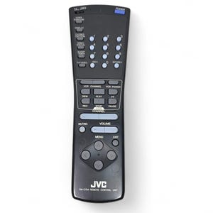 May include: A black JVC remote control with numerous buttons, including power, volume, and channel controls. The remote has a rectangular shape with rounded edges and the brand name "JVC" is visible at the bottom. The model number is FM-C754.