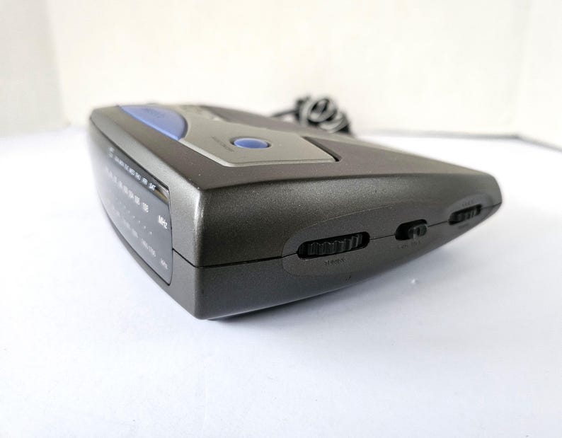 May include: A gray electronic device with a blue accent and several buttons on the side. The device has a digital display with the text "MODE" and "LEFT/RIGHT" visible.