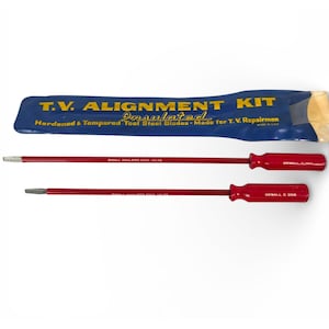 May include: A T.V. Alignment Kit with two red screwdrivers and a blue pouch. The screwdrivers have red handles and silver tips. The pouch has the text "T.V. Alignment Kit" and "Insulated". The screwdrivers are labeled "OXWALL E 200".