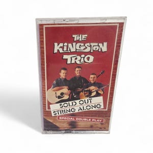 May include: A vintage cassette tape featuring "The Kingston Trio" album. The cover is red with the band's name in white and the album title "Solid Cut String Along". The band members are pictured with guitars.