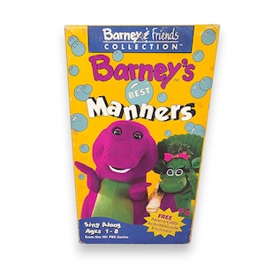 May include: A vintage VHS tape for "Barney's Best Manners" from the "Barney & Friends Collection." The cover features Barney the dinosaur and a green dinosaur, set against a yellow background with bubbles. Includes text: "Sing Along Ages 1-8" and "FREE Parent/Child Activity Guide Enclosed."