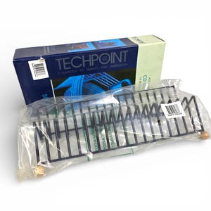 May include: A black metal CD rack with wooden end caps is packaged in clear plastic. A blue and green box behind the rack reads "TECHPOINT" and "COMMITTED TO QUALITY AND INNOVATION."