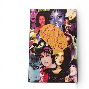 May include: A rectangular item with a collage of women's faces in various colors. The text "the Most Beautiful GIRL in the WORLD" is in a yellow speech bubble. The item has a white border.
