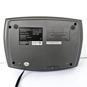 May include: A gray clock radio with a black power cord. The clock radio has a digital display, AM/FM radio, and a clock backup feature. The text on the back of the clock radio reads "Research Model No. CKSS200 Power Source AC 120V 60Hz 8 Watts DC 3V (Clock Backup) Frequency Range AM 530 - 1710 kHz FM 88 - 108 MHz Listed by ETL 101720", and "Caution Risk of Electric Shock Do Not Open S/N:00609203LS".