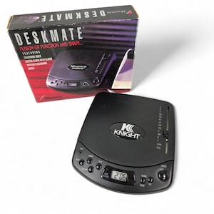 May include: A black DeskMate device with the text "KNIGHT" and a digital clock displaying 2:06. The box reads "DESKMATE" and "FUSION OF FUNCTION AND SHAPE..." with features like a telephone index and alarm.