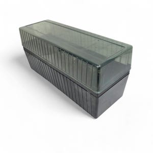 May include: A rectangular, two-piece storage box with a dark gray base and a translucent, ribbed lid. The box is made of plastic and appears to be empty. The lid fits snugly over the base, creating a secure closure.