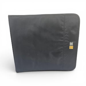 May include: A black Case Logic CD/DVD binder. The binder is made of a textured, durable material. The Case Logic logo is visible on a small yellow tag on the right side of the binder. The binder is closed and has a curved edge.