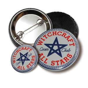 Puede incluir: Dos botones redondos con pasador con fondo blanco y texto azul y rojo. El botón más grande dice "Witchcraft Coven All Stars Club" con una estrella azul de cinco puntas en el centro. El botón más pequeño dice "Witchcraft Coven All Stars Club" con una estrella azul de cinco puntas más pequeña en el centro.