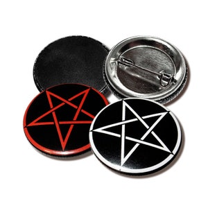 以下が含まれることがあります： 五芒星のデザインが施された、黒と白の丸いボタンピンが3つ。1つのピンは赤い星、もう1つは白い星、もう1つは空白です。
