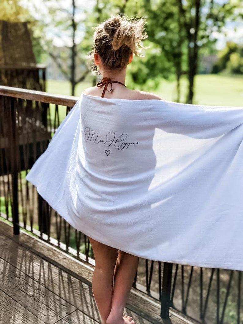 May include: A white towel with the text "Mrs. Higgins" and a small heart symbol embroidered on it.