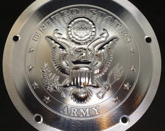 May include: A silver round metal emblem with the words "United States Army" and the United States seal featuring an eagle with a shield and olive branches.