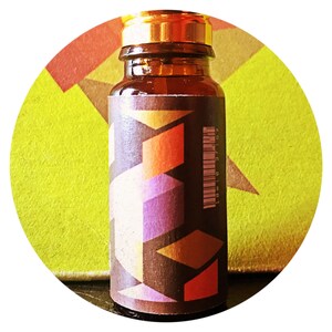 Könnte beinhalten: Eine kleine Glasflasche mit einem goldenen Verschluss und einem Etikett mit geometrischem Muster. Das Etikett zeigt eine Mischung aus braunen, orangen, violetten und weißen Farben. Die Flasche enthält eine Flüssigkeit und hat einen Barcode auf der Seite.