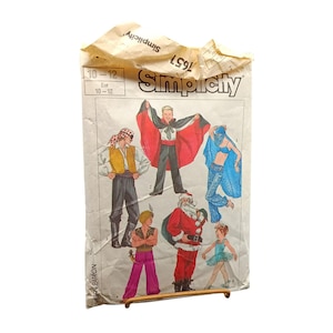 May include: A vintage Simplicity sewing pattern featuring illustrations of children's costumes. The costumes include a pirate, a vampire, a genie, Santa Claus, and a ballerina. The pattern is for sizes 10-12.