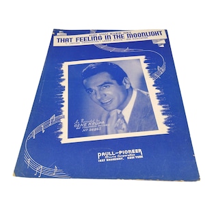 May include: A blue vintage sheet music cover titled Did You Ever Get That Feeling In The Moonlight, featuring a portrait of Gene Krupa. The cover includes musical staff lines, notes, and the publisher name Paull-Pioneer Music Corporation, New York.