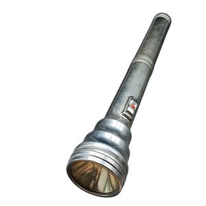 May include: A vintage silver flashlight with a ribbed head and a red button. The flashlight has a cylindrical body and a reflector at the front. The metal shows signs of wear, suggesting it's an older model.