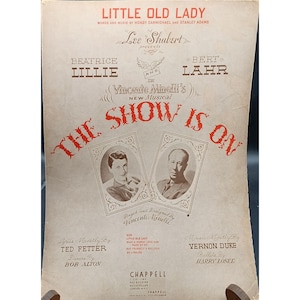 Puede incluir: Partitura de "Little Old Lady" con Beatrice Lillie y Bert Lahr. El título "The Show Is On" está en rojo. Escenificada y diseñada por Vincente Minelli. Publicada por Chappell.